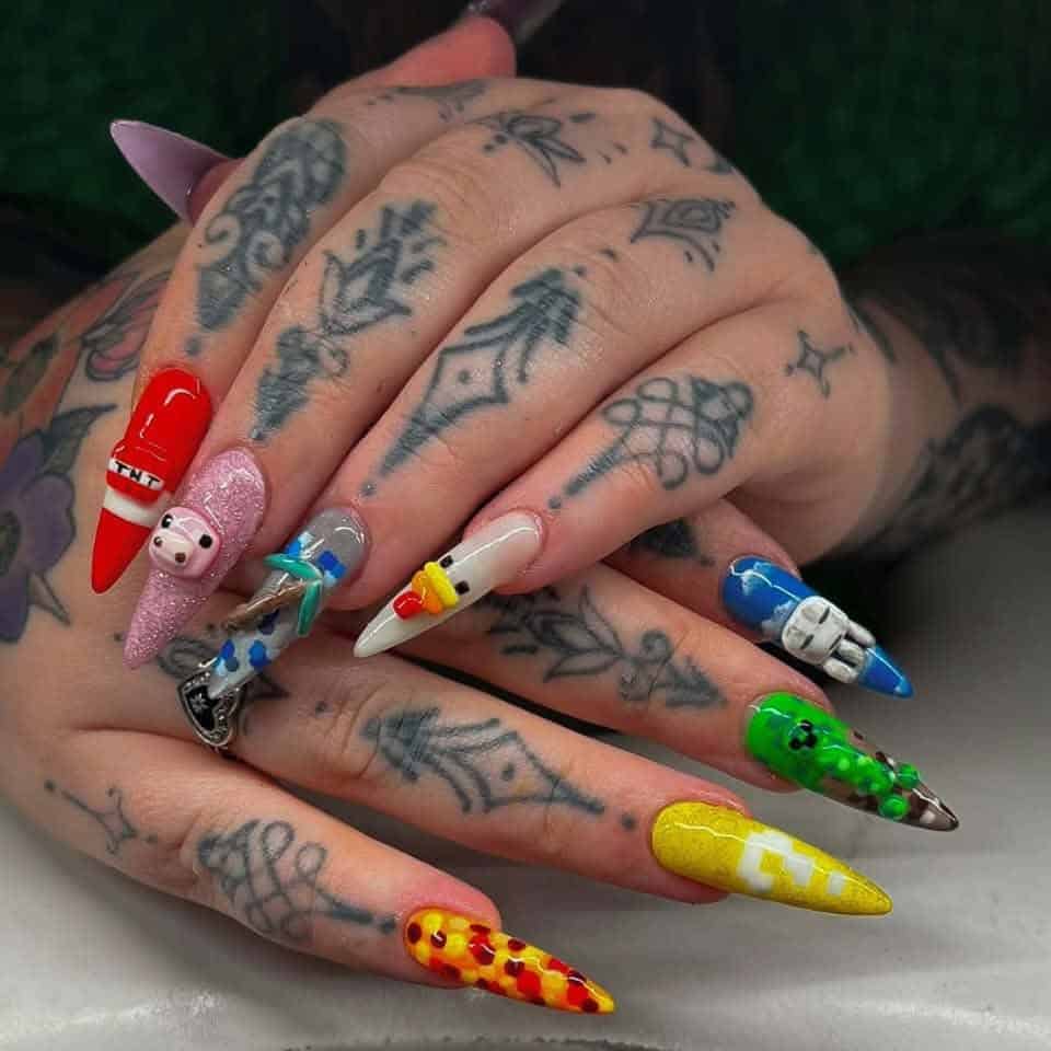 Tattooed hands displaying colourful 3D character-themed stiletto nails