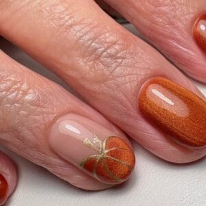 Rust-red glitter nails with gold floral accent design