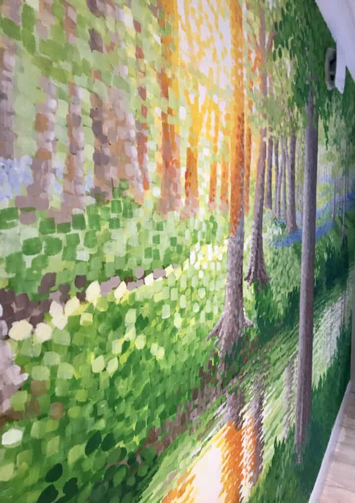 Impressionistic painting of sunlit trees beside a woodland path