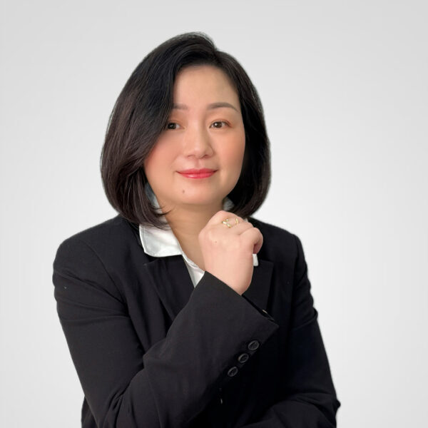 Professional woman in black blazer posing against white background
