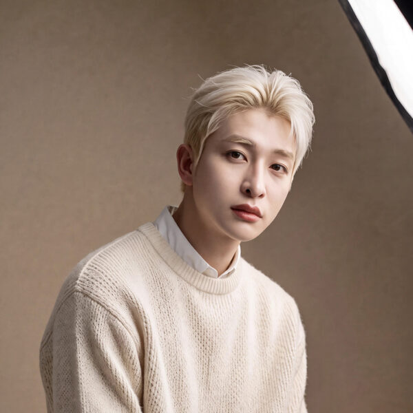 Studio portrait of a blond-haired man in cream knitwear