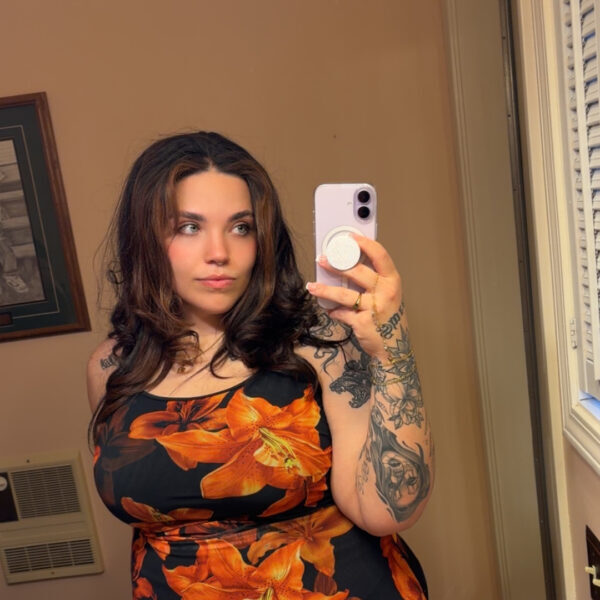 Woman takes mirror selfie wearing orange floral dress